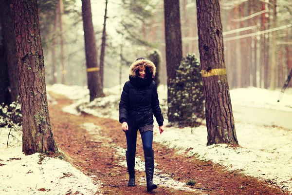 Mulher está caminhando pela floresta no inverno. — Fotografia de Stock