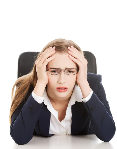 Besorgte, traurige Geschäftsfrau am Tisch. Stockbild