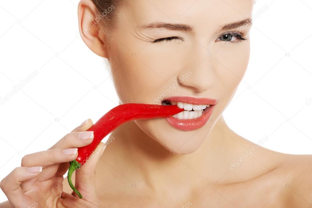 Woman with chili pepper in mouth.