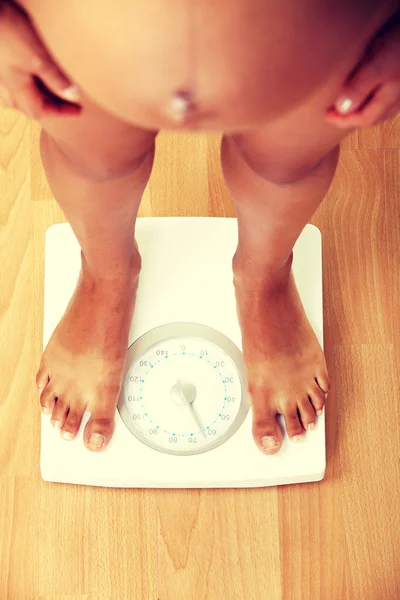 Mujer embarazada comprobando su peso — Foto de Stock