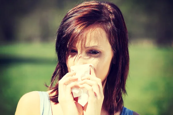Mulher com alergia limpando seu nariz escorrendo — Fotografia de Stock
