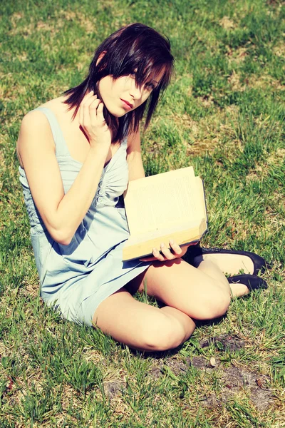 Ung kvinna läser bok — Stockfoto