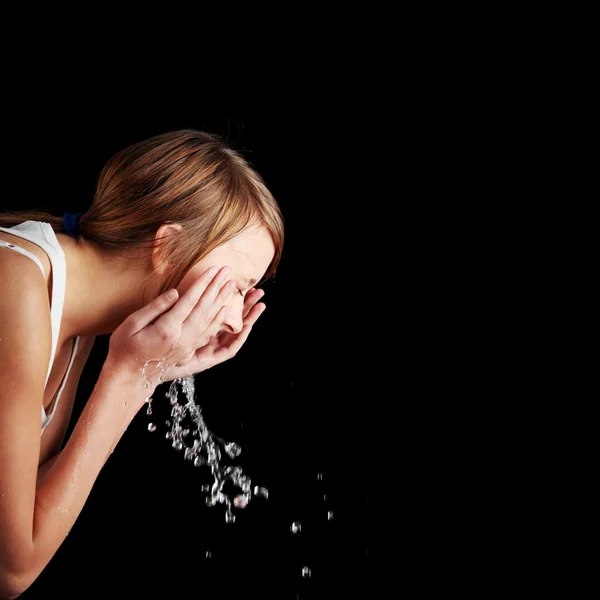 Adolescente chica lavándose la cara con agua — Foto de Stock