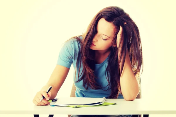 Dospívající dívka studuje na stole být unavený — Stock fotografie