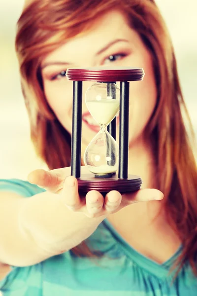 Женщина держит песочные часы — стоковое фото