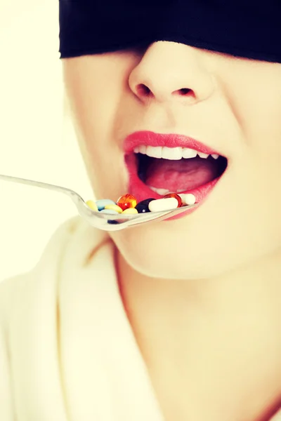 Woman holding spoon with pills — Stock Photo, Image