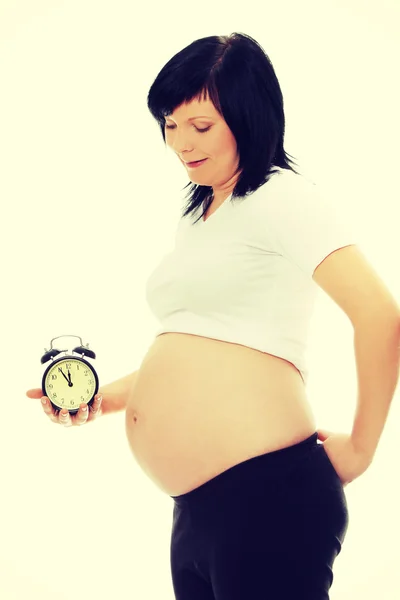 Pregnant woman holding alarm clock — Stock Photo, Image