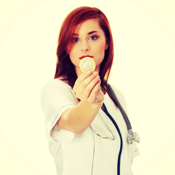 Female Doctor holding condom — Stock Photo, Image