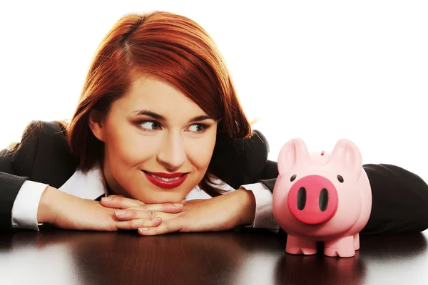 Young business woman looking on pink piggy bank — Stock Photo, Image