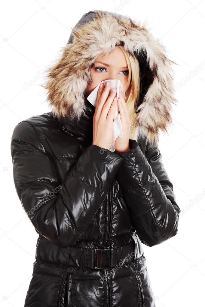 Woman sneezes during cold day