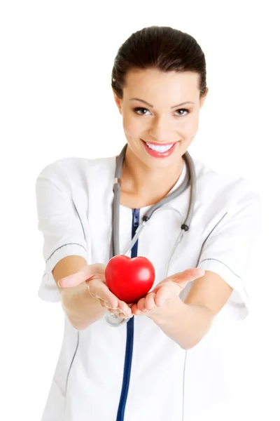 Enfermera joven con el corazón en la mano — Foto de Stock