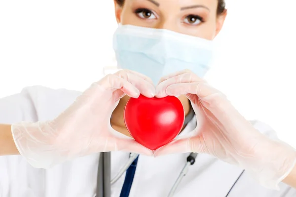 Young nurse with heart in her hand — Stock Photo, Image