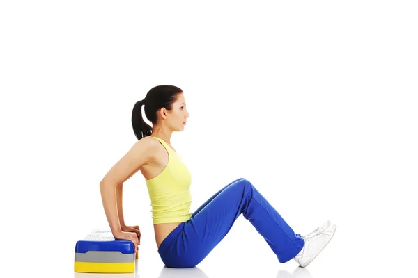 Fitness girl is working out with stepper — Stock Photo, Image