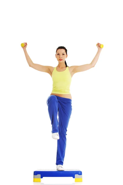 Fitness girl is working out with stepper — Stock Photo, Image