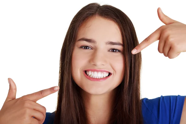 Adolescente menina apontando em seus dentes perfeitos — Fotografia de Stock