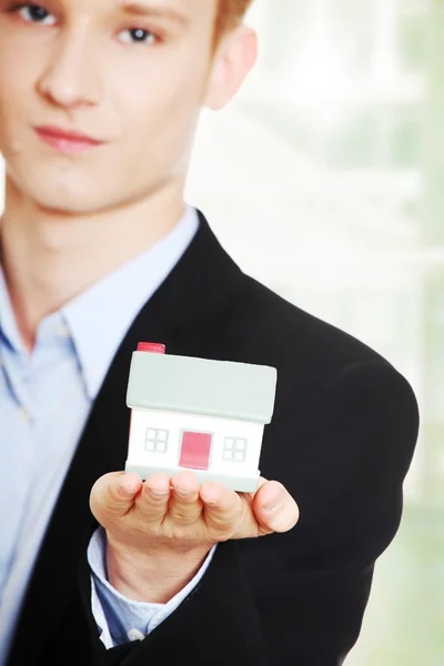 Zakenman holding house model — Stockfoto