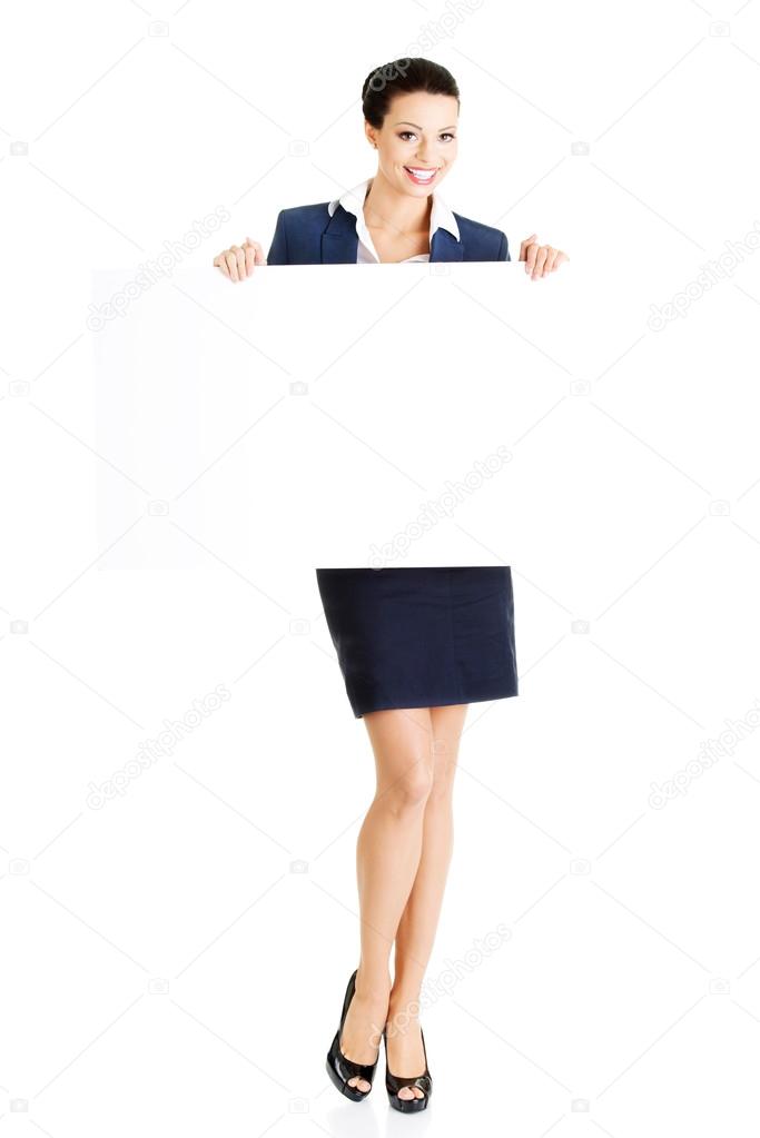 Smiling business woman showing blank signboard