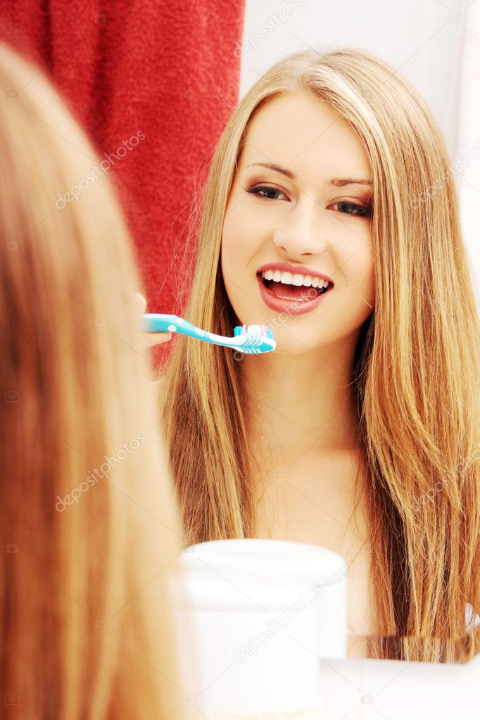 Pretty female brushing her teeth 