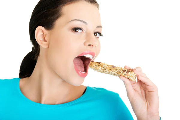 Young woman eating Cereal candy bar — Stock Photo, Image