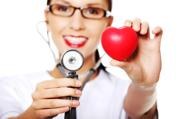 Médica feminina segurando coração vermelho na mão — Fotografia de Stock