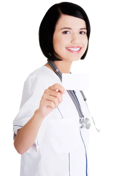 Woman doctor or nurse holding business card — Stock Photo, Image