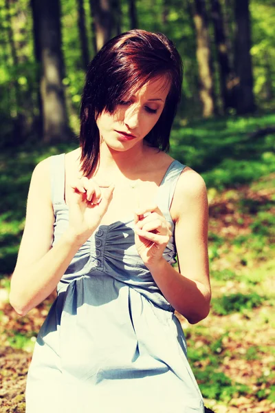 Young woman is counting petals of flower. — Stock Photo, Image