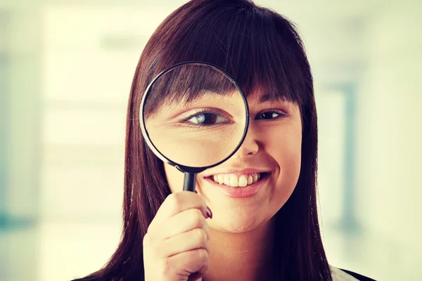 Business woman looking into a magniying glass — Stock Photo, Image