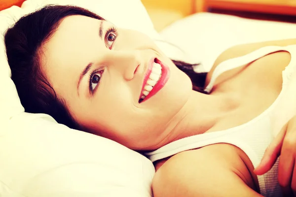 Krásná mladá žena odpočívá v posteli. — Stock fotografie