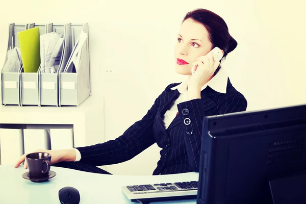 Mulher de negócios sentada atendendo o telefone . — Fotografia de Stock