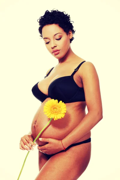 Pleased pregnant woman dressed in black lingerie. — Stock Photo, Image