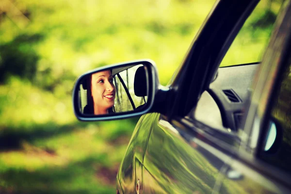 거울에서 볼 수 있는 차를 운전 하는 여자. — 스톡 사진