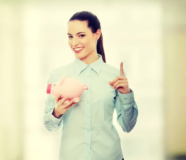 Empresária segurando banco porquinho — Fotografia de Stock