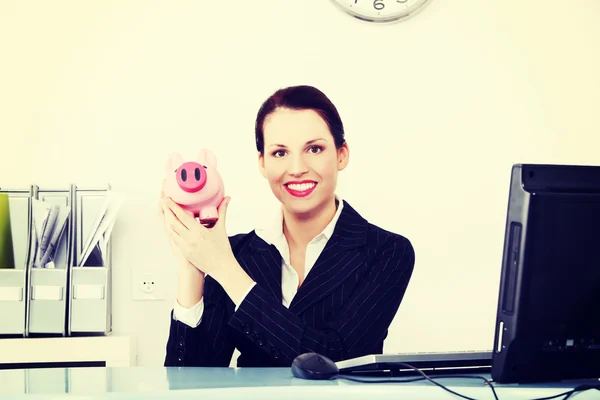 Geschäftsfrau hält Sparschwein. — Stockfoto