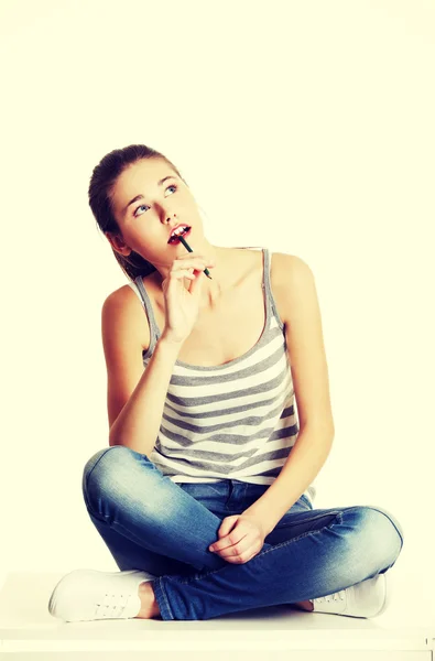 Nachdenkliche weibliche Teenager sitzen auf einem Tisch. — Stockfoto