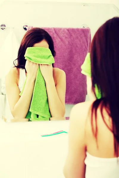 Vrouw afvegen van haar gezicht met een handdoek. — Stockfoto