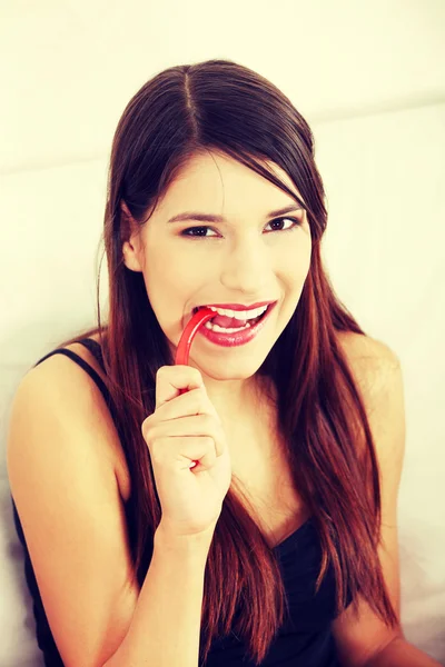 Jonge vrouw is het eten van snoep. — Stockfoto