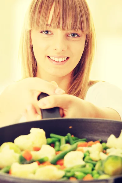 Giovane donna cucina cibo — Foto Stock