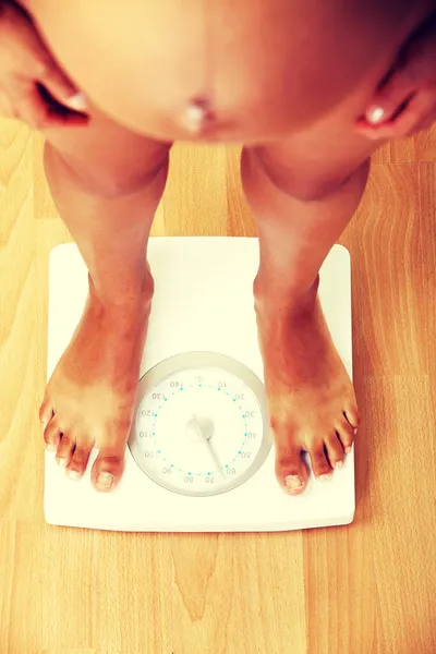 Mujer embarazada comprobando su peso — Foto de Stock