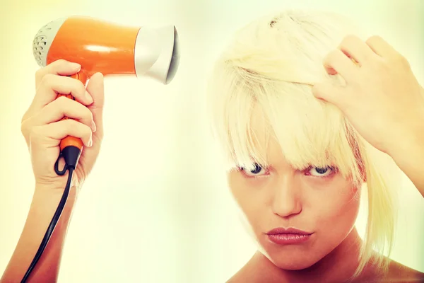 Blonde woman using hair drier — Stock Photo, Image