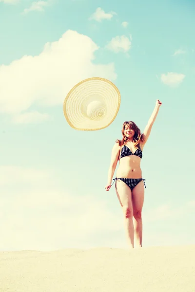 Mujer joven en bikini está lanzando su sombrero de verano. —  Fotos de Stock
