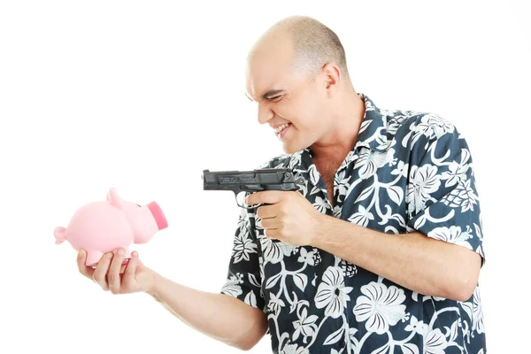 Mann mit Waffe zeigt auf Sparschwein — Stockfoto