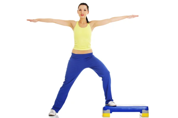 Fitness girl is working out with stepper — Stock Photo, Image