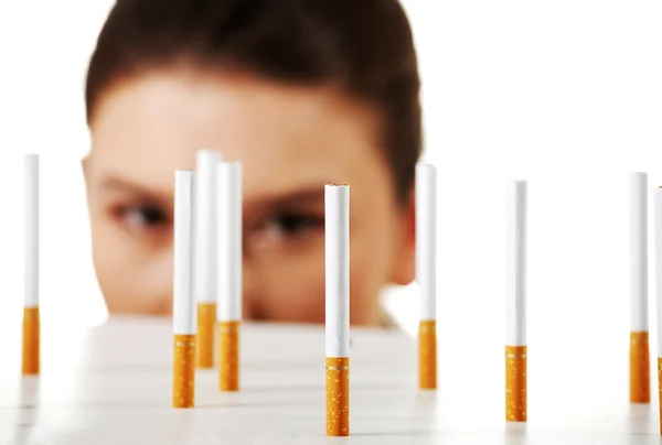 Junge Frau schaut auf Zigaretten — Stockfoto