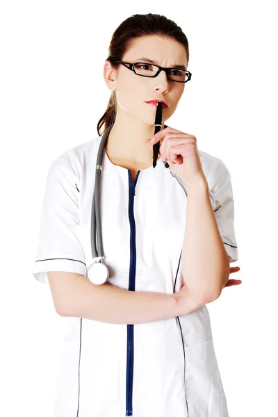 Jeune femme réfléchie médecin avec un stylo — Photo