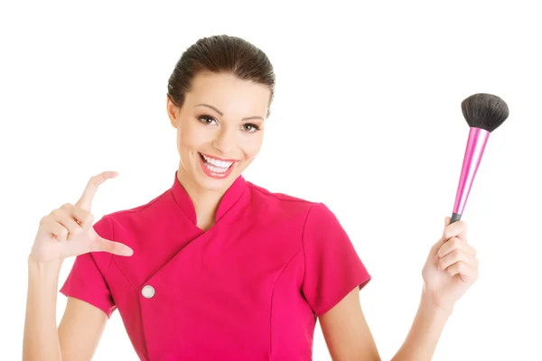 Joven maquilladora mujer mostrando espacio de copia — Foto de Stock