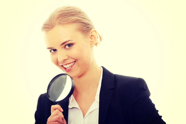 Business woman looking into a magnifying glass — Stock Photo, Image