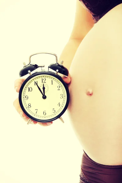 알람 시계와 함께 임신한 여자의 배 — 스톡 사진