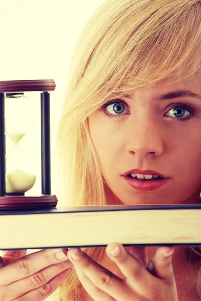 Teenager with book and hourglass — Stock Photo, Image