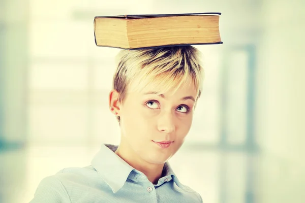 Student woman with book on head — Stock Photo, Image