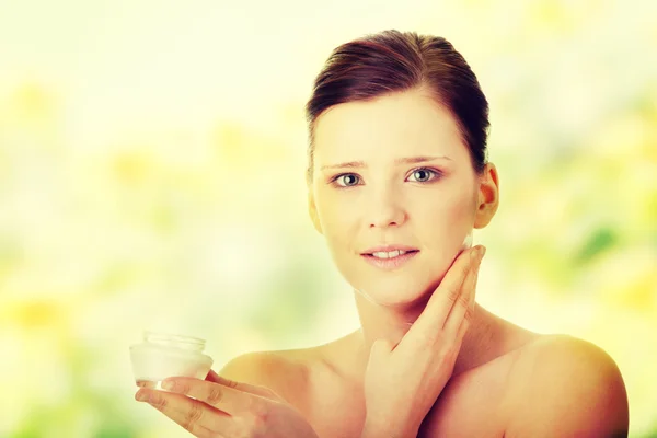 Vrouw toepassing moisturizer crème op gezicht — Stockfoto